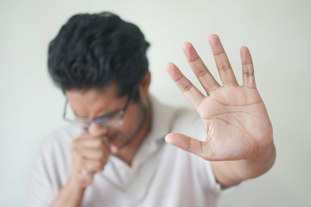 pexels-photo-9882204-9882204 Unwell man covering cough with hand, showing sign of illness